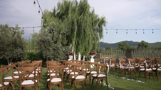 Elegant wedding ceremony setup with empty chairs on a green lawn before the event begins ,fa01