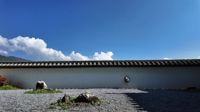 Time Lapse White Clouds Moving Across Blue Sky Over Traditional Japanese Garden Wall Gravel Stone Landscape