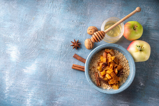 Autumn tasty breakfast Oatmeal Porridge with Apple and Cinnamon in bowl, top view. Healthy balanced morning meal, oats with baked apple