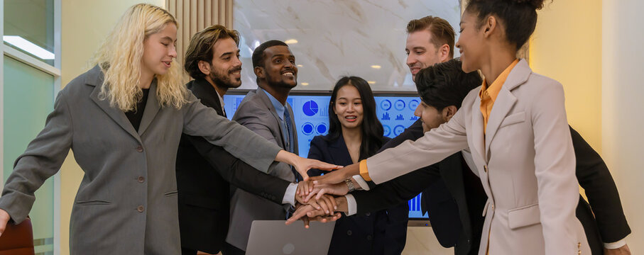Diverse colleagues gather in brainstorm discuss statistics together. Group of people colleagues gather showing unity with their hands together. 