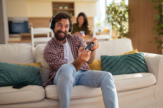 Excited man playing video game at home