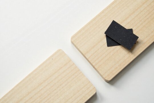 Close-up View of Two Light-Colored Wooden Rectangles with Small Pieces of Dark Abrasive Material