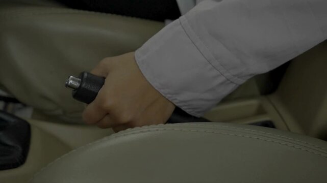 Close-up of a hand pulling a car handbrake inside vehicle, symbolizing automotive safety, driving control, transport detail, and modern mobility lifestyle.