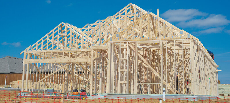 Construction activity persists around Dressage Ln, echoing growth across northern suburbs. Visible wood framed walls stand against morning atmosphere, signaling residential density. Aubrey, TX