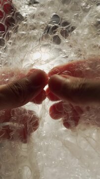 Close-Up of Hand Popping Bubble Wrap for Stress Relief and Relaxation