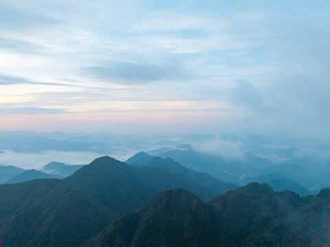 The beautiful landscape of Sanqingshan Mountain in Jiangxi China shows rolling peaks and misty valleys under a soft morning sky during a quiet and peaceful day