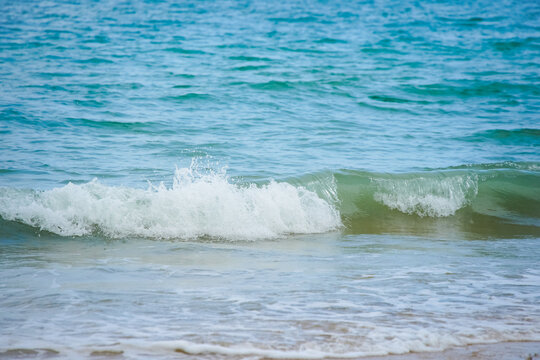 Gentle turquoise waves lapping a sandy shore