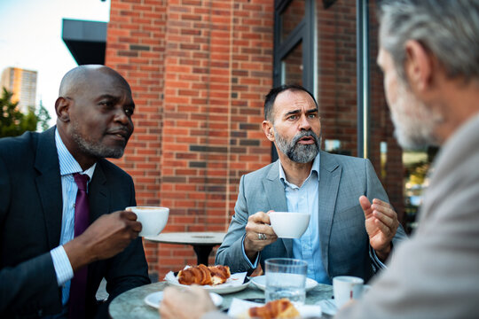 Business executives discussing over coffee at outdoor cafe