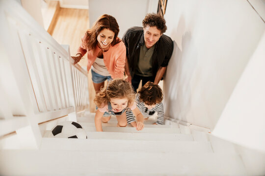 Parents and children climbing stairs at home