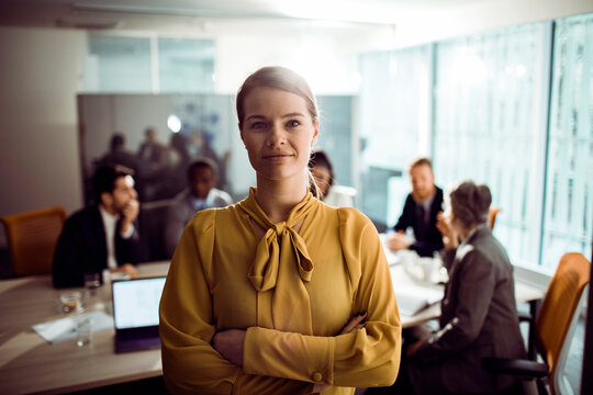 Confident businesswoman leading team meeting in modern office