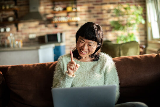 Smiling woman on laptop video call in living room