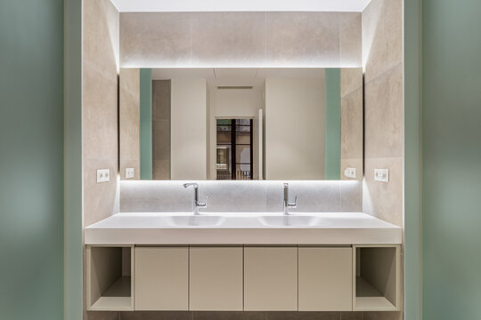 Modern bathroom interior with double sinks, illuminated mirror, sleek cabinetry, neutral tones, and spacious minimalist design for refined home renovation, with bathroom, modern, interior, double