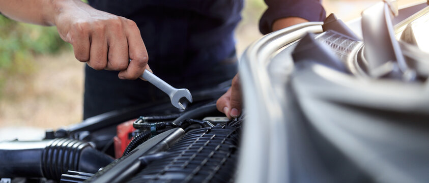 Automobile mechanic repairman hands repairing a car engine automotive workshop with a wrench, car service and maintenance,Repair service.