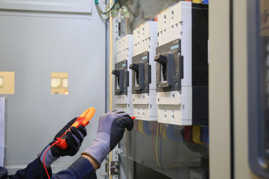 Electricians use a meter to measure the current at the main breaker of the MDB cabinet to check the voltage.