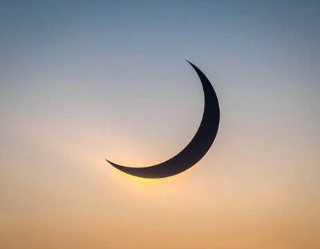 Black crescent shape blocking the sun in a hazy pale gray sky