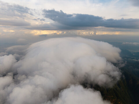 A scenic aerial view showing thick clouds rolling over the peaks of Sanqingshan Mountain located in the Jiangxi province of China during a bright sunny day