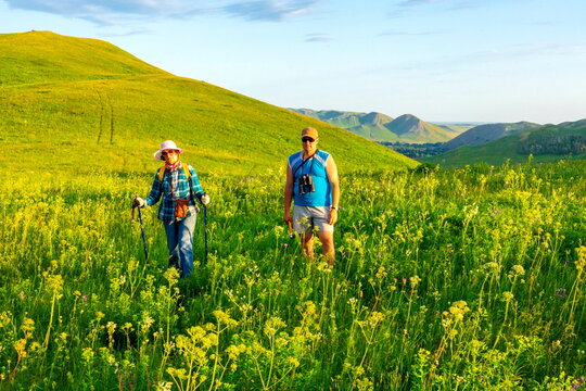 tourists men and women walk along the ridges of the Southern Urals on a summer day