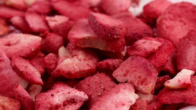 Red freeze dried strawberry slices falling down close up