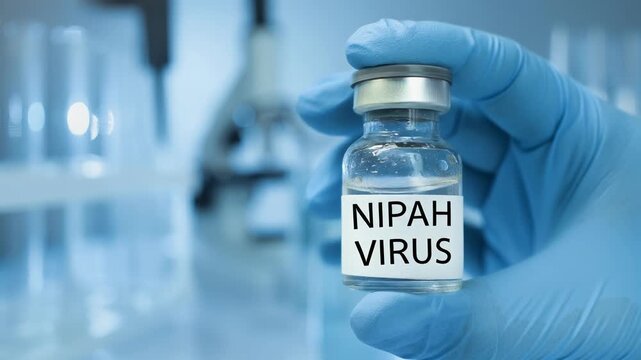 Close up of vial labeled Nipah virus held by gloved hand in medical laboratory environment