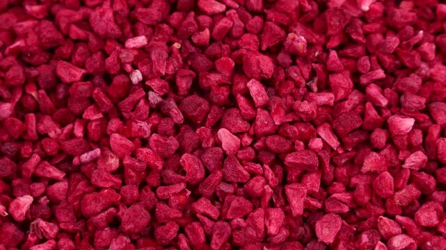 Red freeze dried raspberry slices texture circle rotation close up top view