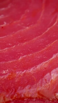 Fresh red tuna slice texture circle rotation close up, vertical video