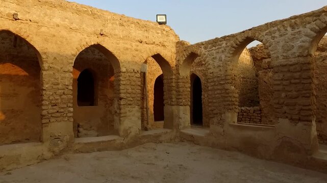 Mud brick wall under natural light in desert landscape during daytime showing dry structure and open terrain.