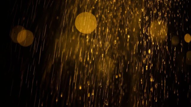 Golden rain drops falling at night with glowing bokeh lights background