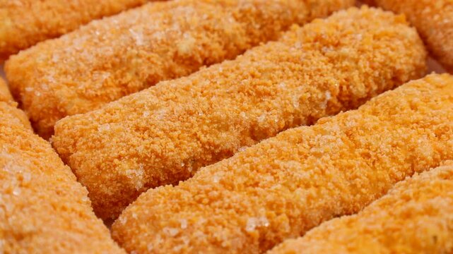 Frozen fish fingers with breadcrumbs circle rotation close up