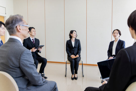 ビジネスミーティングで意見交換をする多世代のビジネスチーム
