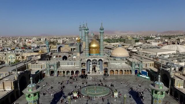 Historic mosque with golden domes and minarets under clear sky in urban landscape during daytime showing Islamic architecture.
