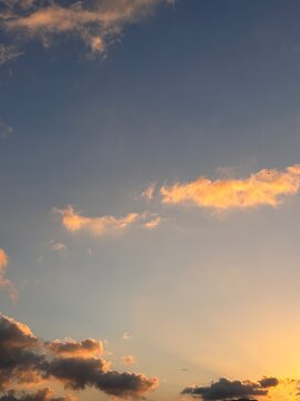 Dramatic crepuscular rays piercing through scattered clouds in the evening sky. Meteorological background showing atmospheric changes at sunset.