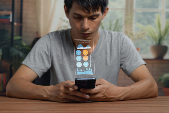 Young Man Analyzing Data on Smartphone with Digital Graphs in Indoor Environment