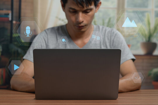 Young Man Using Laptop with Digital Technology Icons in Modern Indoor Setting