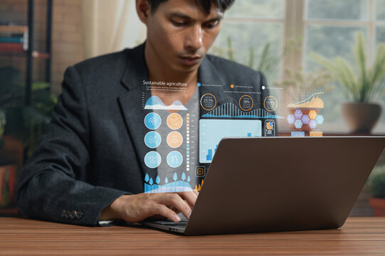Young Man Analyzing Data on Laptop in Modern Office Environment