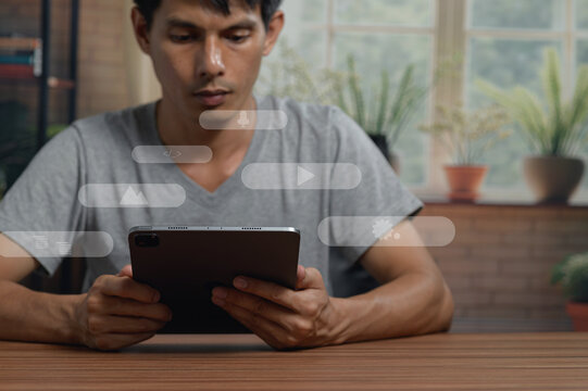 Young Man Using Tablet Device at Table in Cozy Indoor Setting