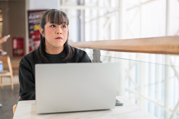 Fototapeta premium Thai Transgender Woman Working on Laptop and Looking Out Window