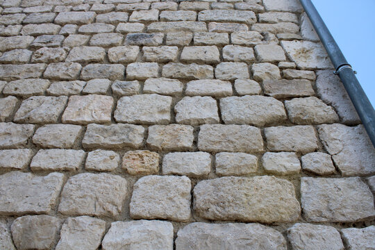 Mur en pierres sans joint &ndash; d&eacute;croutage d&rsquo;enduit ou piquage d&rsquo;enduit pour rejointoiement du mur.