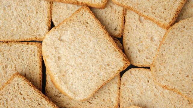 Rotating food background with textured organic grain bread slices, flat lay.