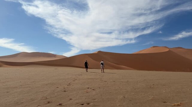Two male adult adventurers exploring dunes in Sossusvlei Desert, Namibia Africa