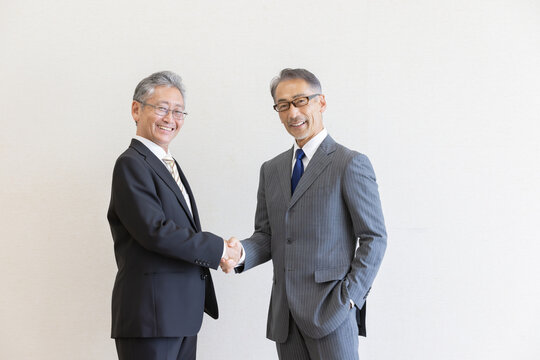 握手を交わすシニアビジネスパーソンのパートナーシップ