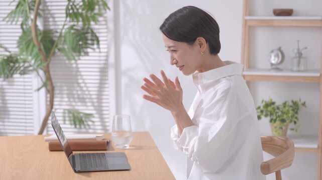 ノートパソコンを見て応援する女性