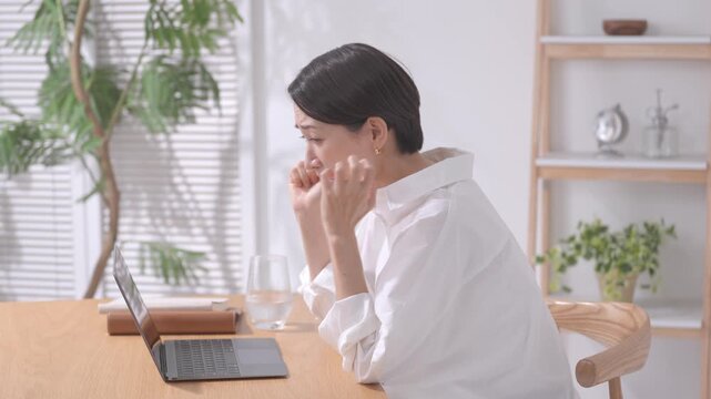 ノートパソコンを見て応援する女性