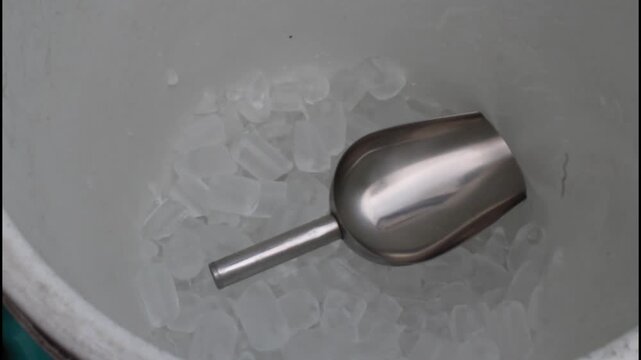 Ice tube and ice scoop in an ice bucket of a iced tea street food vendor. Iced tea is a staple of street food scenes across southeast asia

