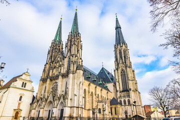 Fototapeta premium Front facade of the neo-Gothic St. Wenceslas Cathedral with two high spires under a cloudy sky in Olomouc.