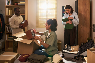 Plakat Young man unpacking speaker in bedroom while middle aged parents sorting belongings during move in day, showing college transition. Ideal for family support or student housing marketing