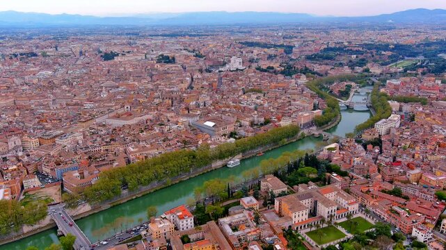 Aerial view of the historic center of Rome, Italy, with the Tiber river, Ponte Sisto bridge, the Pantheon dome, Victor Emmanuel monument, the Colosseum and mountains at dusk in spring.