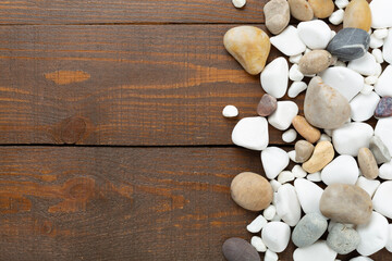 White pebble stones on wooden background, top view © Liami