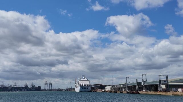 Southampton docks Hampshire England UK. 29.06.2026. A white  cruise ship  is moored at a bustling maritime terminal with industrial cranes and cargo containers visible in the background