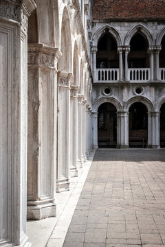 Venetian courtyard arches. Stone pillars and gothic arcade inside historic Doge Palace in Venice Italy.