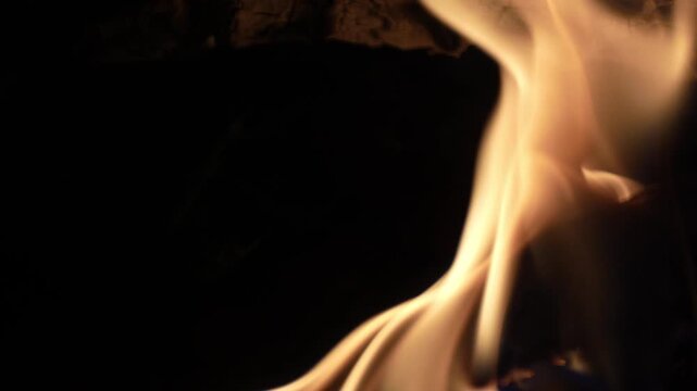 Elegant golden fire flames twisting gracefully against a black backdrop, perfect for high-quality video overlays.